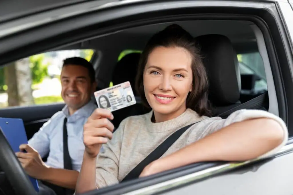 Une heureuse candidate à réussir son examen de conduite et présente son permis de conduire. 